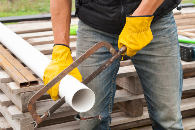 Gutter Repairs by worker with a saw and yellow gloves on